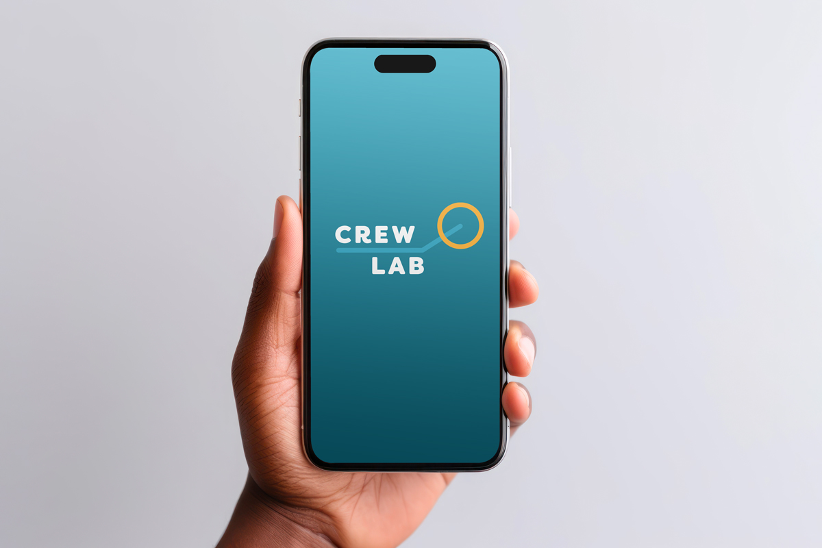 Hand holding a mobile phone with the CrewLAB logo on the screen. 