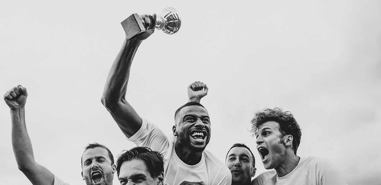 Athletes celebrating victory with their trophy